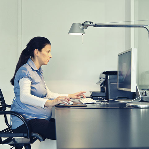 Schwangere am Schreibtisch vor einem Computer