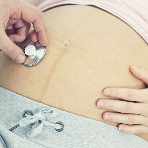Bauch einer schwangeren Frau wird untersucht. 